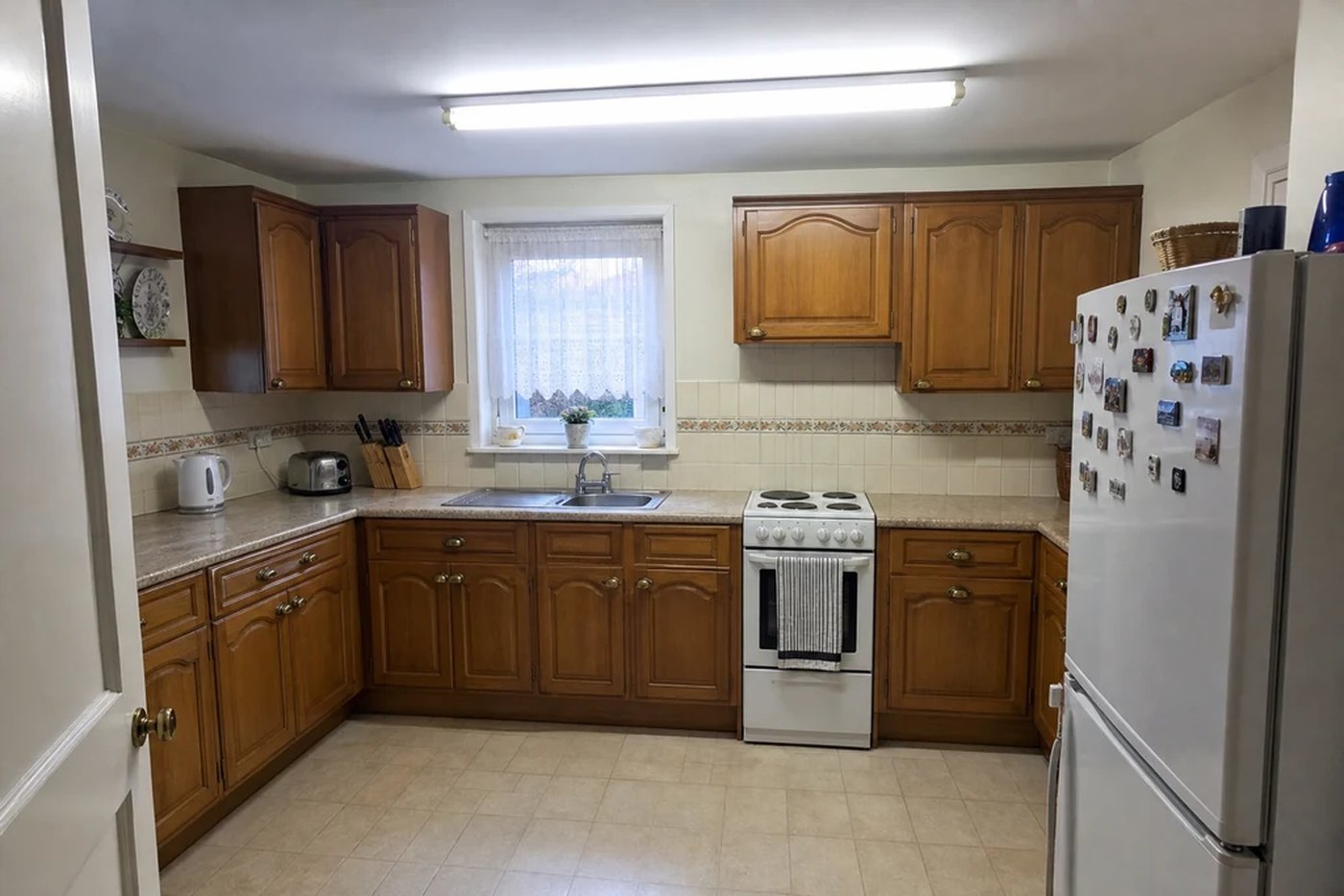 A kitchen photographed as it is: dark timber cabinets, patterned tiles.